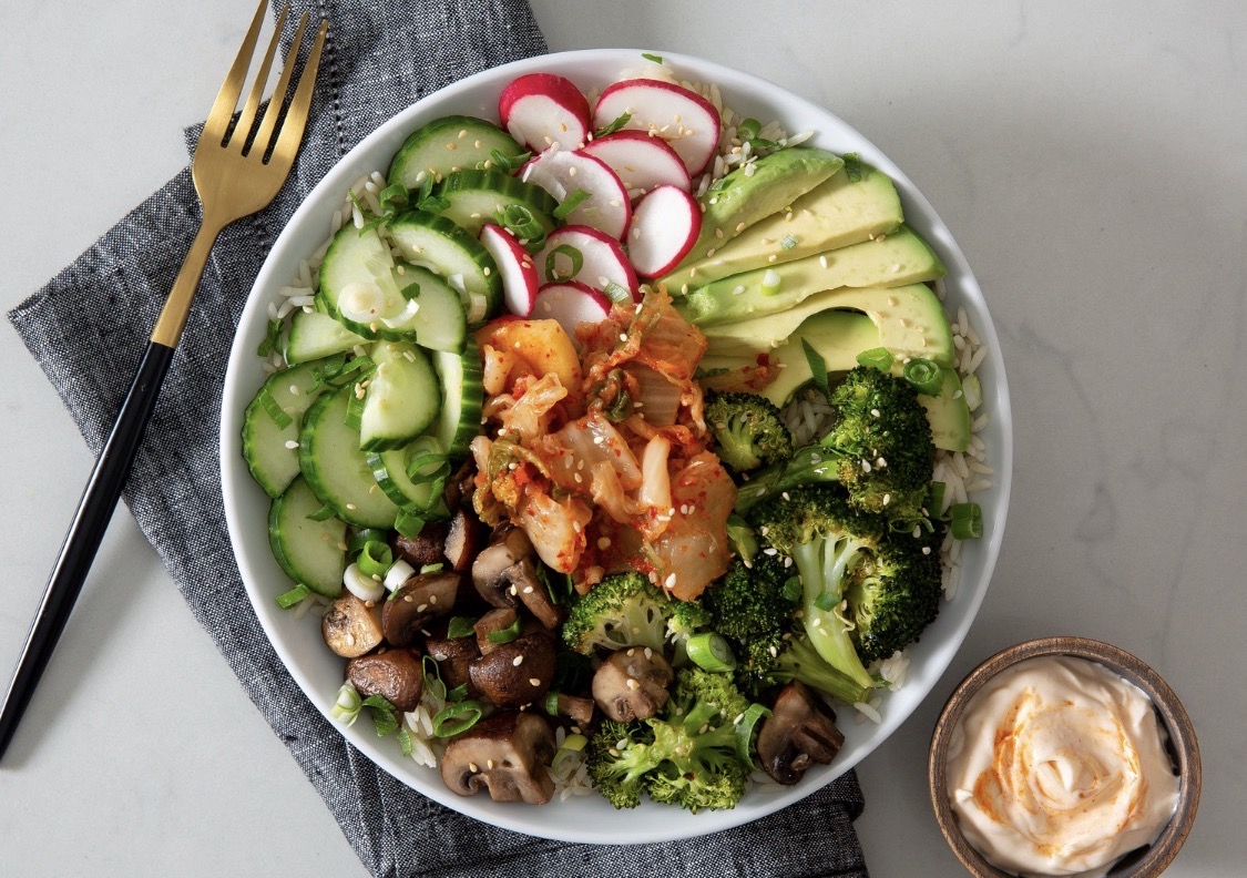 Kimchi rice bowl with cucumber, radish, avocado, broccoli and mushrooms